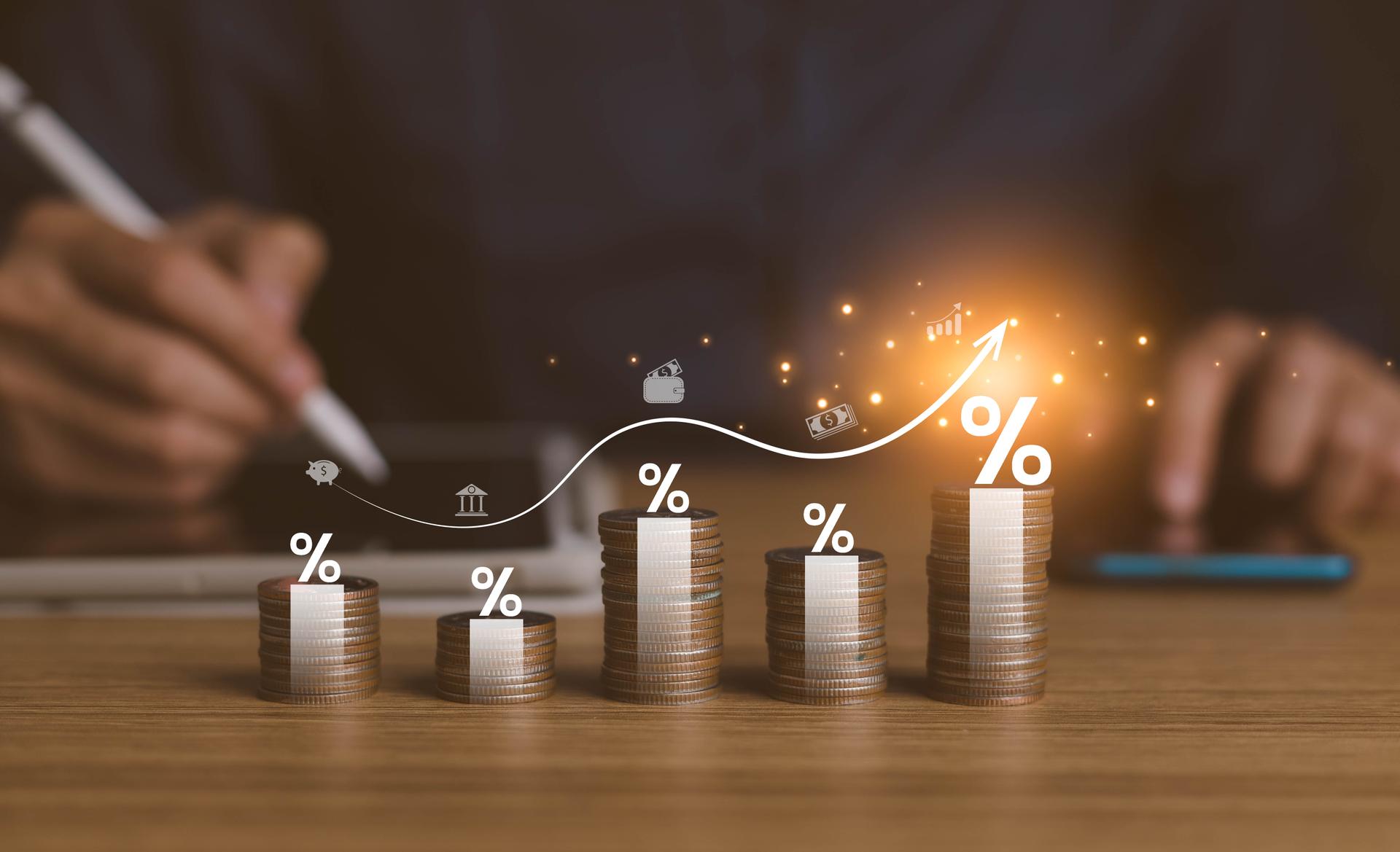 interest rates and dividends, investment returns, income, retirement Compensation fund, investment, dividend tax. pile of coins and upward direction percentage symbol. saving money for investment